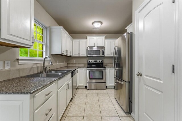 701 W Thornstone Ave, West Fork, AR 72774 - kitchen featuring appliances with stainless steel finishes, a sink, white cabinetry, light tile patterned floors, and dark stone countertops