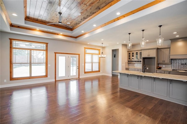 kitchen with gray cabinets, a raised ceiling, baseboards, wood ceiling, and gas stovetop
