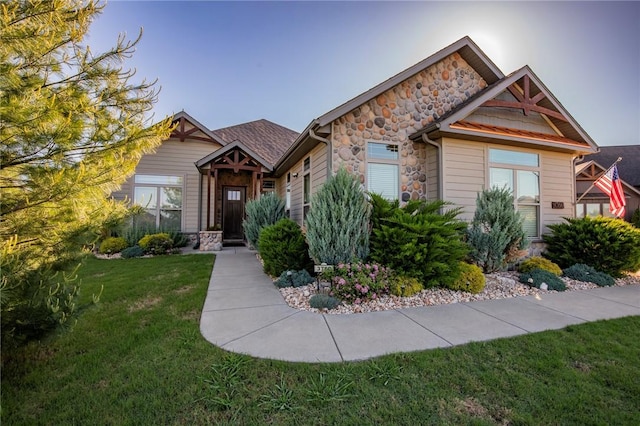 craftsman house with stone siding and a front lawn