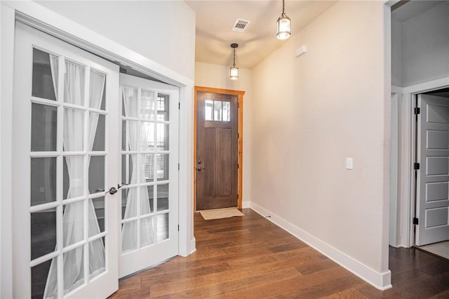 foyer with baseboards and wood finished floors