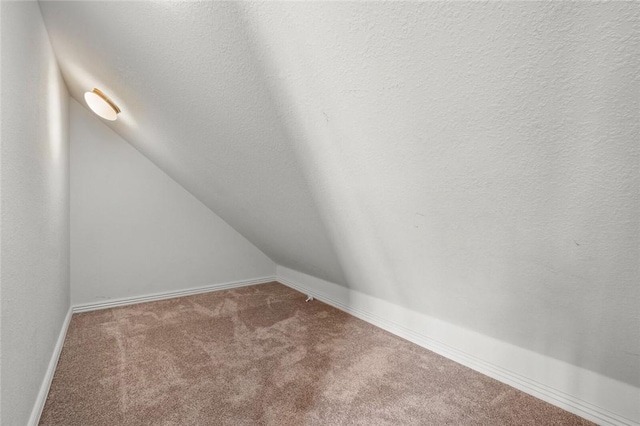 3907 NE Cadbury Ave, Bentonville, AR 72712 - carpeted empty room with lofted ceiling and baseboards