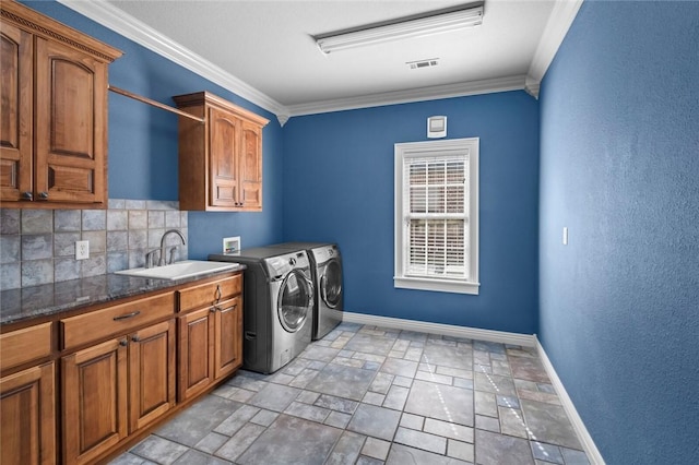 3907 NE Cadbury Ave, Bentonville, AR 72712 - laundry room with cabinet space, baseboards, washing machine and clothes dryer, light stone finish flooring, and crown molding