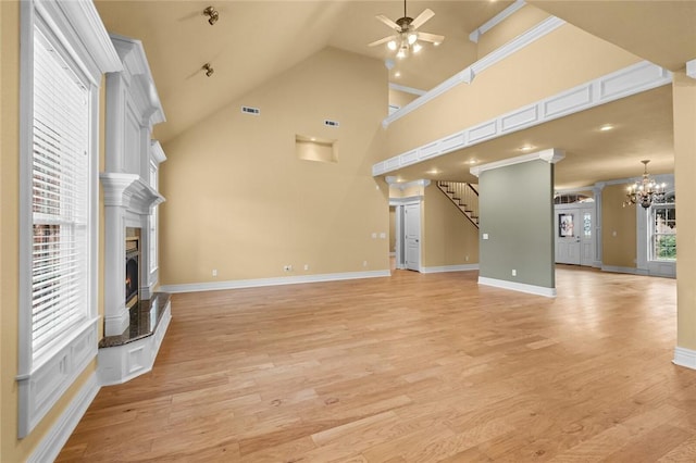 3907 NE Cadbury Ave, Bentonville, AR 72712 - unfurnished living room with ceiling fan, a lit fireplace, a chandelier, baseboards, and crown molding
