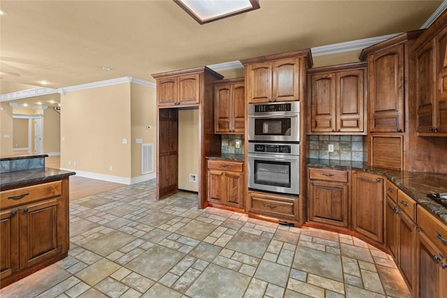 3907 NE Cadbury Ave, Bentonville, AR 72712 - kitchen featuring stainless steel double oven, light stone finish floors, ornamental molding, tasteful backsplash, and baseboards