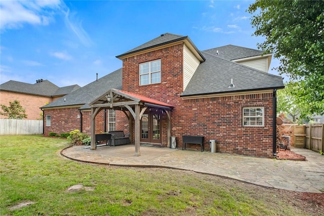 3907 NE Cadbury Ave, Bentonville, AR 72712 - back of property featuring roof with shingles, brick siding, french doors, and a patio