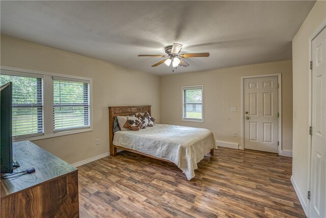 bedroom featuring wood finished floors, baseboards, and ceiling fan