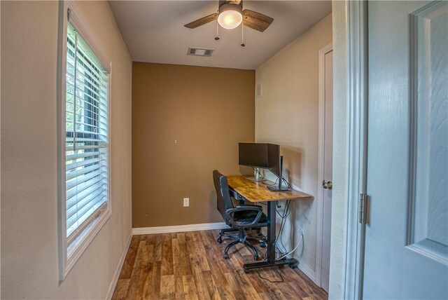 office space with healthy amount of natural light, wood finished floors, a ceiling fan, and baseboards