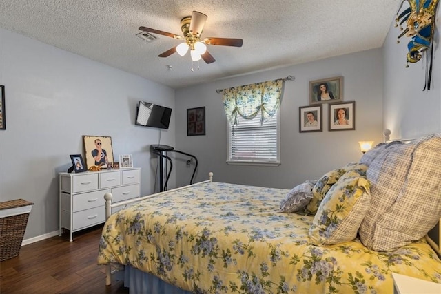 bedroom featuring dark wood-type flooring, a textured ceiling, baseboards, and a ceiling fan