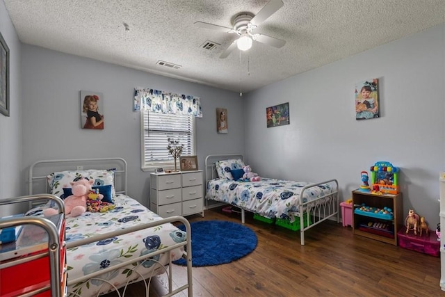 bedroom with wood finished floors, a textured ceiling, and a ceiling fan