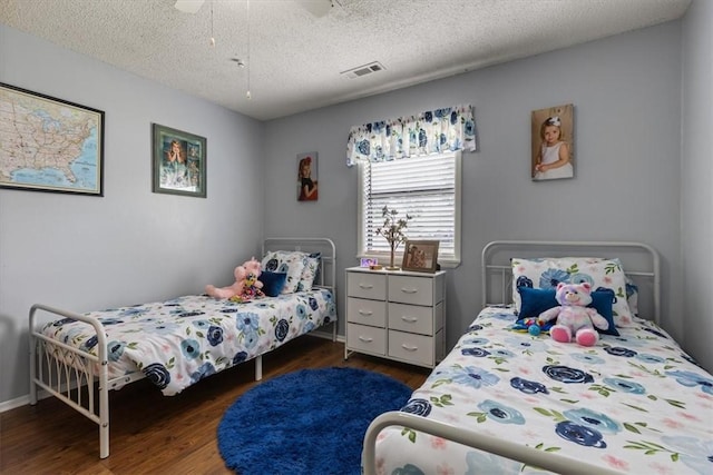 bedroom featuring wood finished floors, a textured ceiling, a ceiling fan, and baseboards