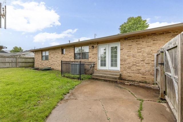 back of property with brick siding, entry steps, and a patio area
