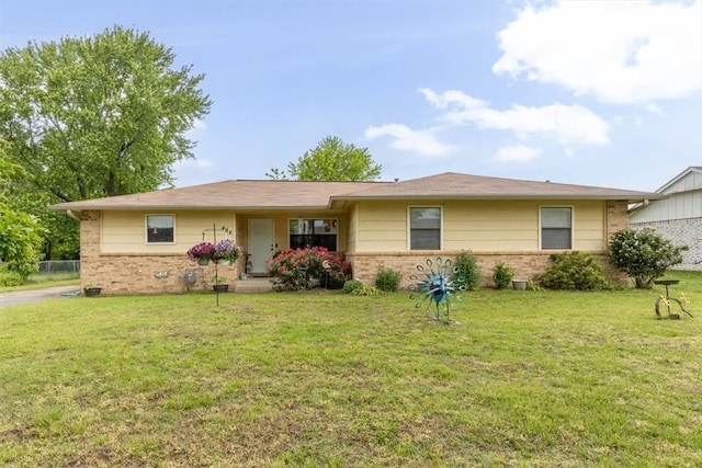 ranch-style home featuring brick siding and a front yard