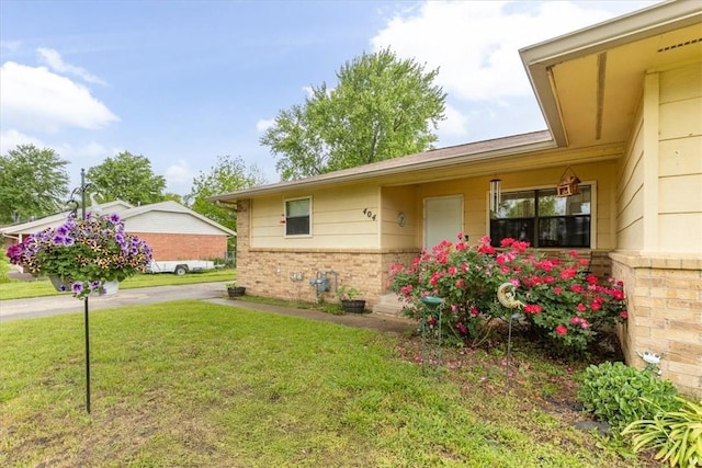 view of front of home with a front lawn and brick siding