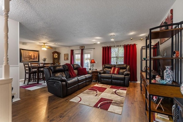 living area featuring a textured ceiling, a ceiling fan, and wood-type flooring