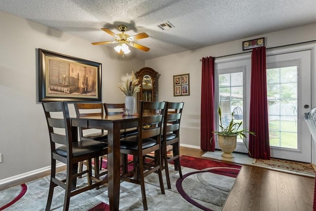 dining space featuring a textured ceiling, ceiling fan, and baseboards