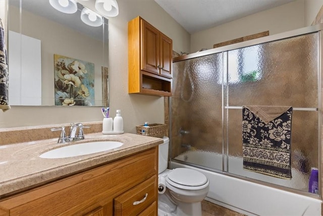 bathroom featuring toilet, enclosed tub / shower combo, vanity, and tile patterned floors
