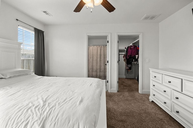 6005 Sherman St, Bentonville, AR 72713 - bedroom featuring dark carpet, a walk in closet, a closet, baseboards, and a ceiling fan