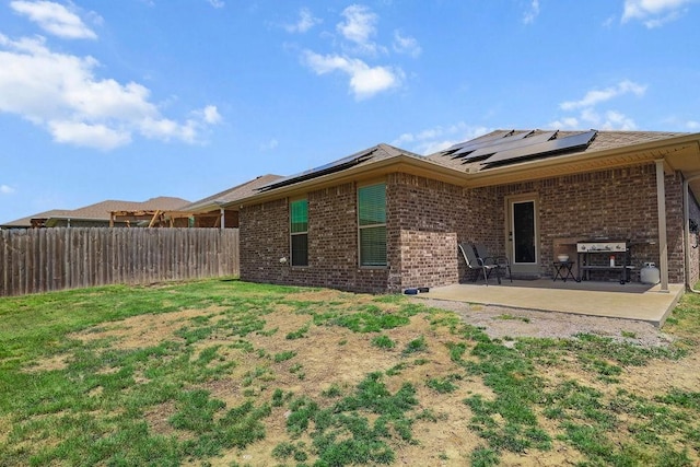 6005 Sherman St, Bentonville, AR 72713 - back of property with brick siding, a patio, and roof mounted solar panels