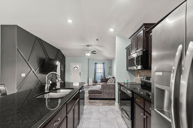 6005 Sherman St, Bentonville, AR 72713 - kitchen featuring stainless steel appliances, a sink, dark stone counters, open floor plan, and a ceiling fan