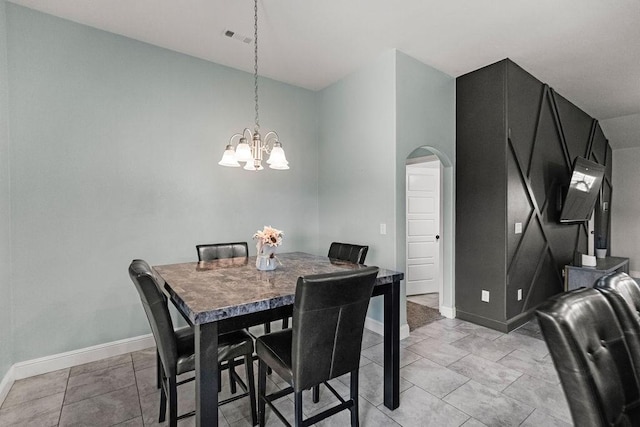 6005 Sherman St, Bentonville, AR 72713 - dining room featuring arched walkways, a chandelier, baseboards, and light tile patterned floors