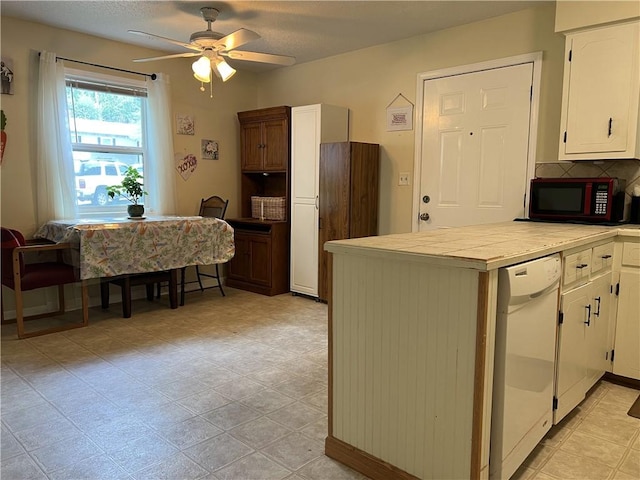 kitchen featuring white dishwasher, white cabinets, ceiling fan, tasteful backsplash, and a peninsula