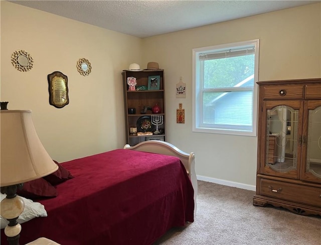 bedroom with carpet floors, baseboards, and a textured ceiling