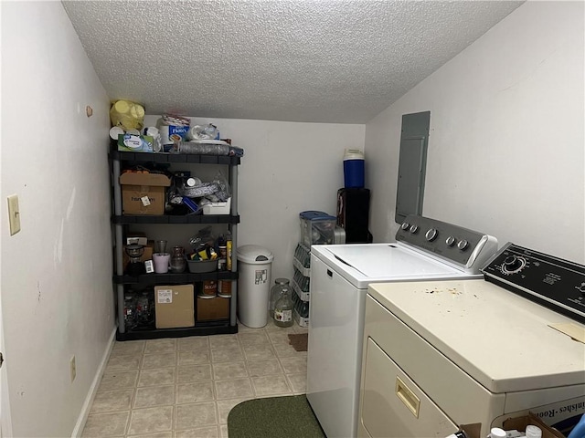 washroom featuring washing machine and clothes dryer, a textured ceiling, and electric panel