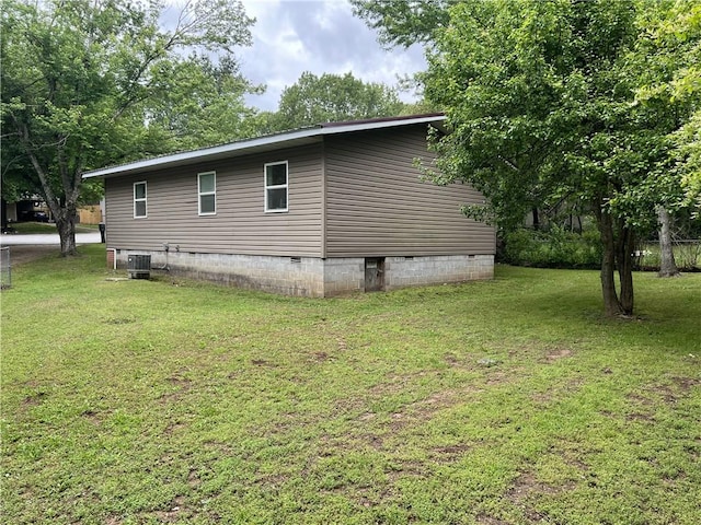 view of side of property featuring crawl space, a lawn, and central AC