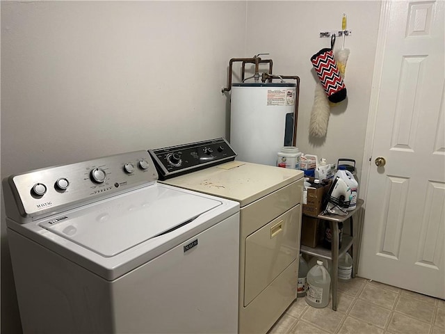 laundry room featuring water heater, separate washer and dryer, and light tile patterned floors
