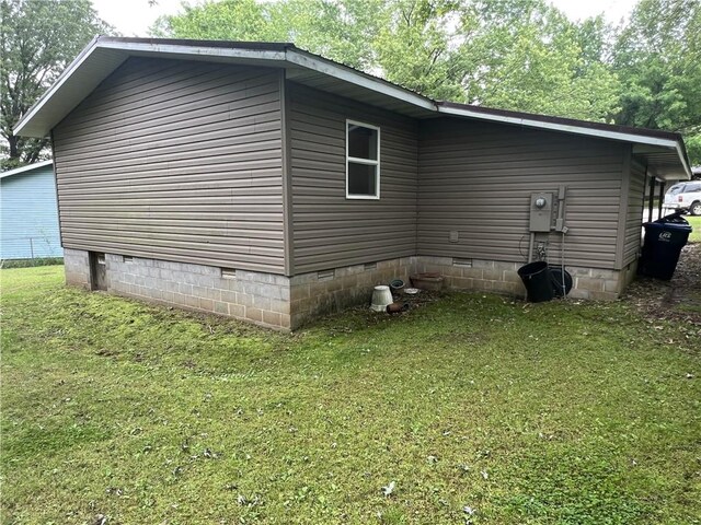 view of side of property with crawl space and a yard