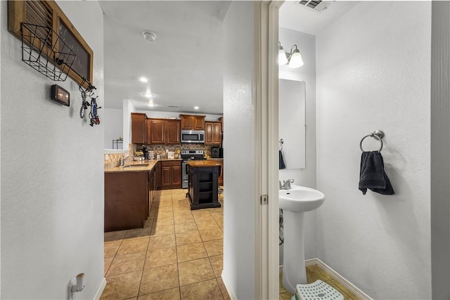 4208 SW Fieldstone Blvd, Bentonville, AR 72712 - bathroom featuring a sink, backsplash, tile patterned floors, baseboards, and recessed lighting
