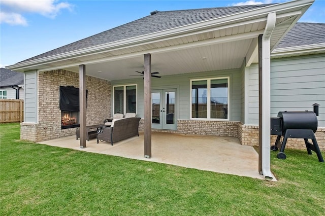 rear view of property with french doors, roof with shingles, an outdoor brick fireplace, and a patio area