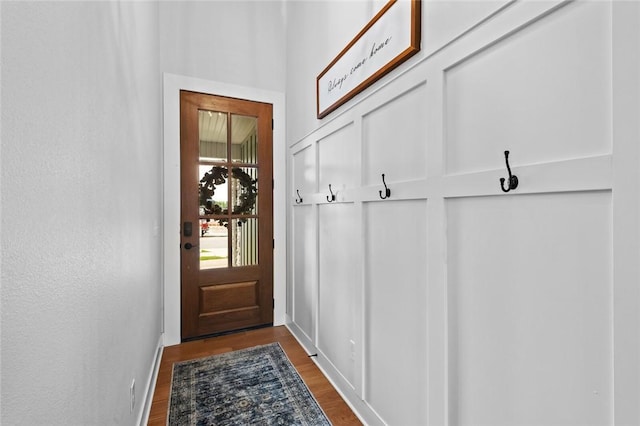 entryway with dark wood finished floors and baseboards