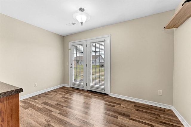 unfurnished dining area featuring wood finished floors and baseboards