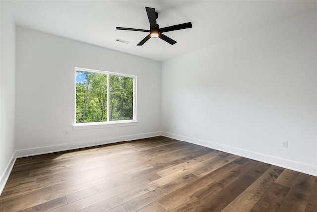 empty room featuring dark wood-style flooring, baseboards, and ceiling fan