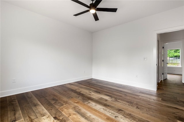 spare room with a ceiling fan, dark wood-style floors, and baseboards