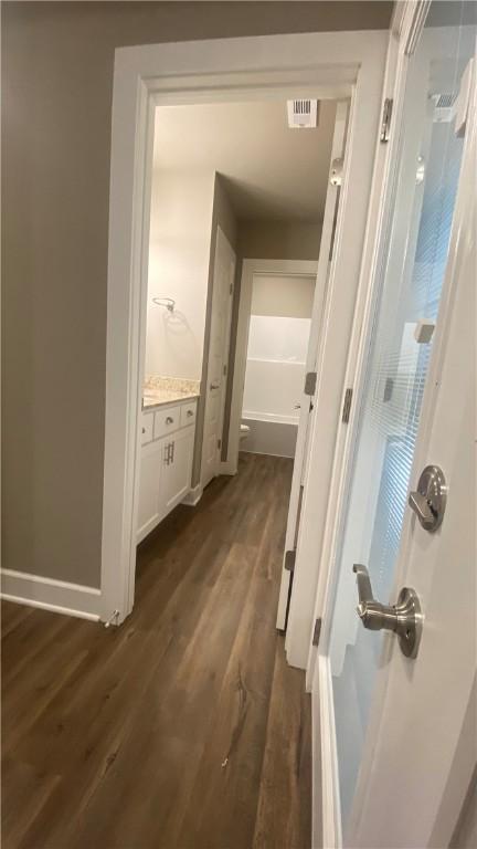 hallway with dark wood-style floors and baseboards