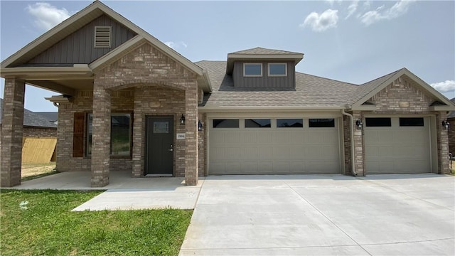 craftsman inspired home with an attached garage, driveway, roof with shingles, and board and batten siding