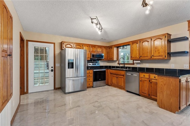 18322 Oakridge Rd, Springdale, AR 72764 - kitchen featuring appliances with stainless steel finishes, a sink, open shelves, brown cabinetry, and dark countertops