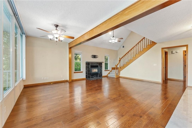 18322 Oakridge Rd, Springdale, AR 72764 - unfurnished living room with a textured ceiling, a ceiling fan, a fireplace, stairs, and baseboards