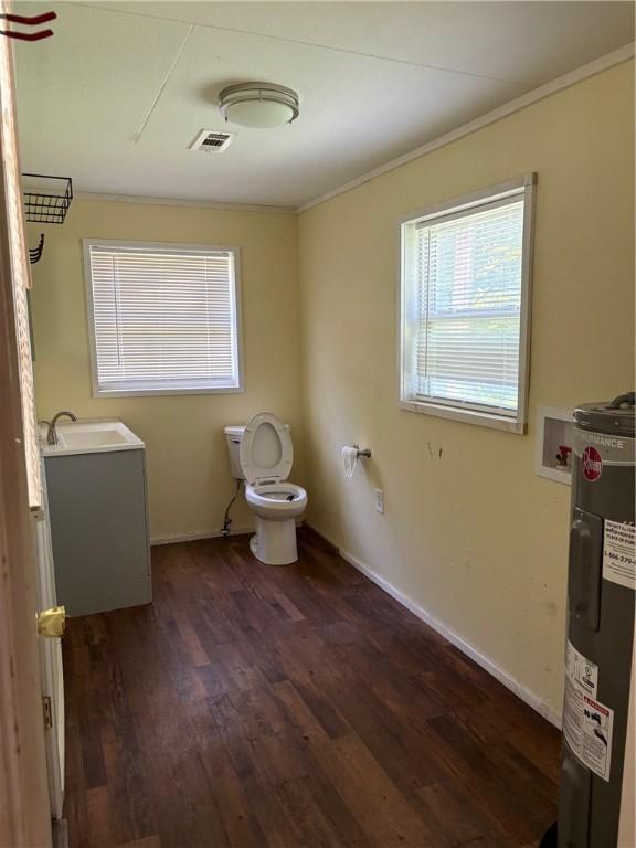 21964 Raven Rd, Elkins, AR 72727 - bathroom featuring electric water heater, ornamental molding, wood finished floors, toilet, and vanity