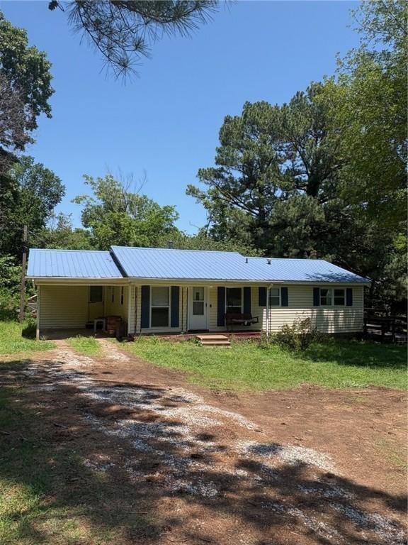 21964 Raven Rd, Elkins, AR 72727 - ranch-style home featuring dirt driveway, covered porch, a carport, and a metal roof