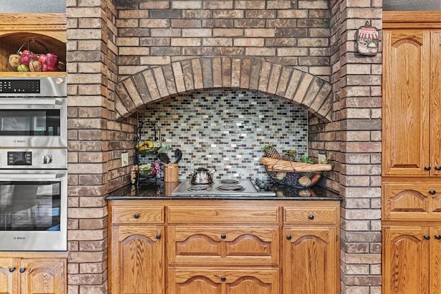 16180 Black Oak Ln, Rogers, AR 72756 - kitchen with appliances with stainless steel finishes, brown cabinetry, and brick wall