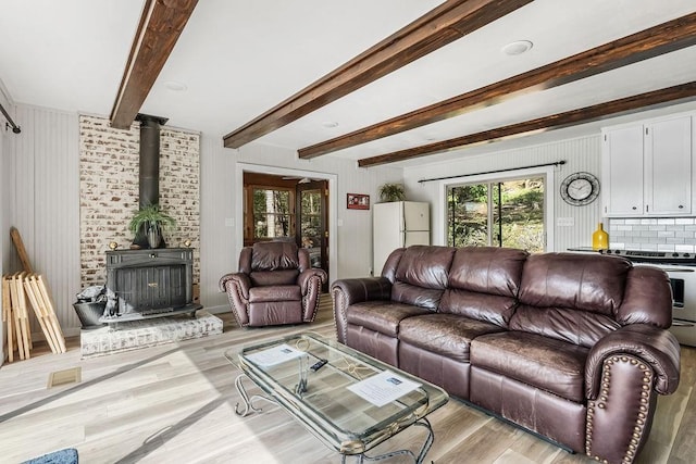 9211 Larue Rd, Rogers, AR 72756 - living room featuring light wood-style floors, a wood stove, and beamed ceiling
