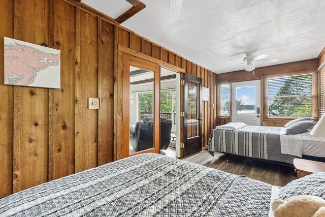 9211 Larue Rd, Rogers, AR 72756 - bedroom with access to outside, wood walls, wood finished floors, multiple windows, and a ceiling fan