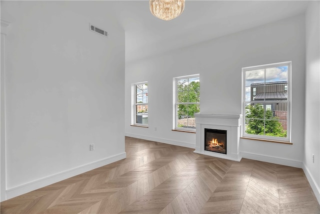 500 SW B St Unit 5, Bentonville, AR 72712 - unfurnished living room with a glass covered fireplace, baseboards, and a chandelier