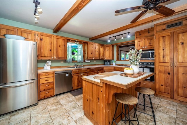 398 Northfork Dr, Berryville, AR 72616 - kitchen with appliances with stainless steel finishes, track lighting, brown cabinetry, light countertops, and beam ceiling