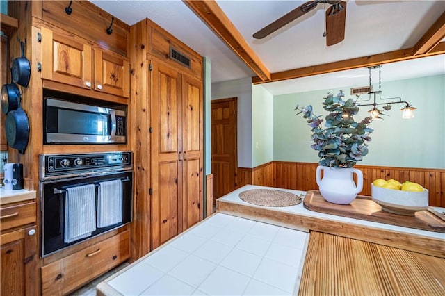 398 Northfork Dr, Berryville, AR 72616 - kitchen with black oven, stainless steel microwave, a wainscoted wall, a ceiling fan, and beam ceiling