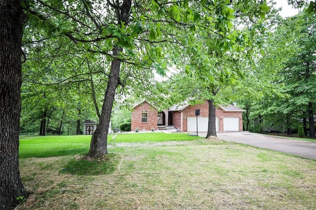 view of front facade with brick siding, concrete driveway, a front lawn, and a garage