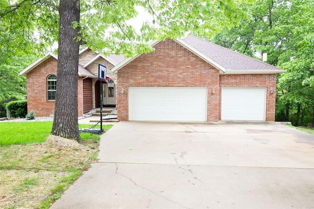 view of front of house with a garage, concrete driveway, and brick siding